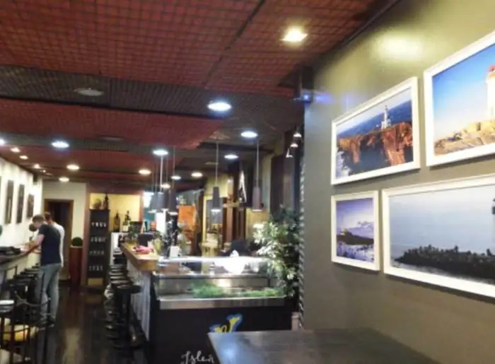 Barra del restaurante con fotografías de paisajes enmarcadas en blanco