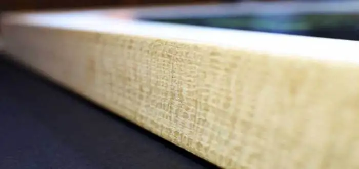 Detalle del canto de una moldura de madera clara