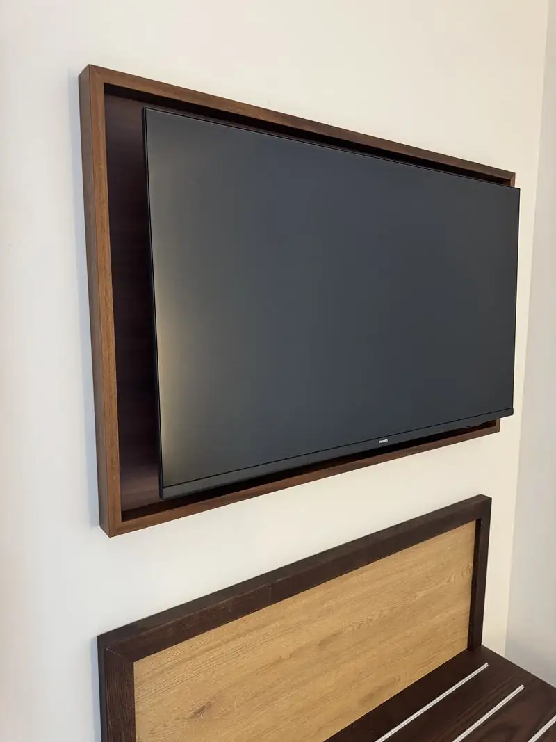 Mueble de televisión de diseño personalizado en madera de nogal sobre el cabecero