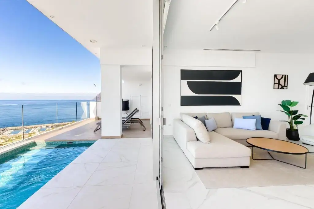 Salón abierto a la piscina con gran obra en blanco y negro enmarcada