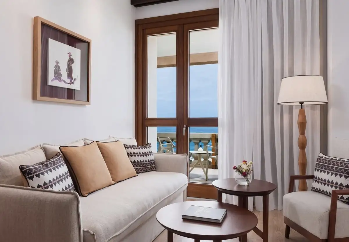 Salón de la suite con sofá, terraza y vistas al mar